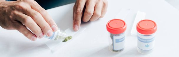 панорамный снимок красивого мужчины, выливающего медицинскую марихуану
 - Фото, изображение