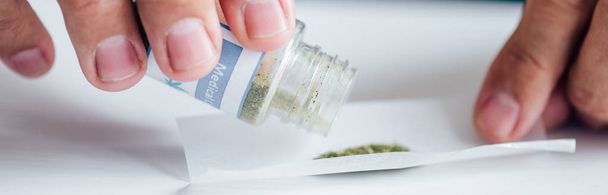 panoramic shot of handsome man pouring out medical cannabis - Photo, Image