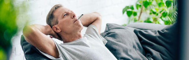 panoramic shot of man smoking blunt with medical cannabis - Foto, imagen