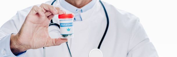 панорамный снимок врача в белом халате, держащего медицинскую марихуану изолированной на белом
  - Фото, изображение
