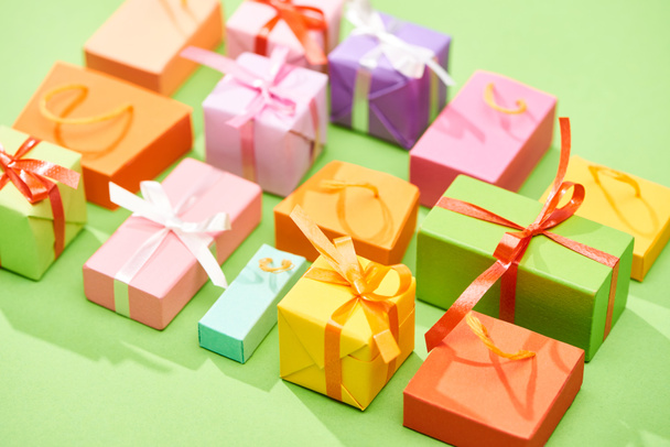 selektiver Fokus der dekorativen bunten Geschenkboxen auf grünem Hintergrund - Foto, Bild