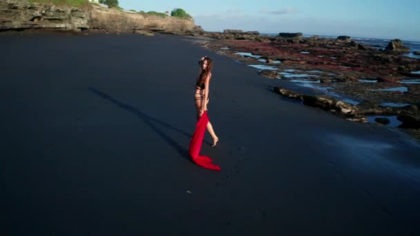 Siyah pırıl pırıl kum plajda poz bikini ve kırmızı genel güzel şehvetli kadın havadan drone görünümü - Video, Çekim