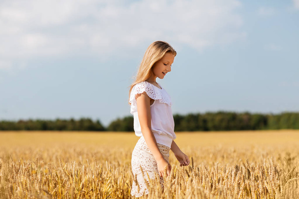 smiling young girl on cereal field in summer - Foto, imagen