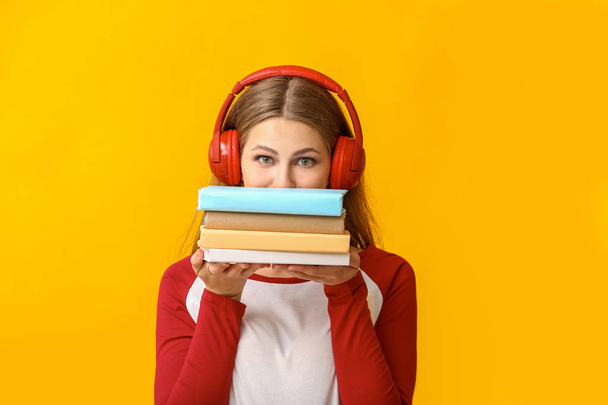 junge Frau hört Hörbuch auf farbigem Hintergrund - Foto, Bild