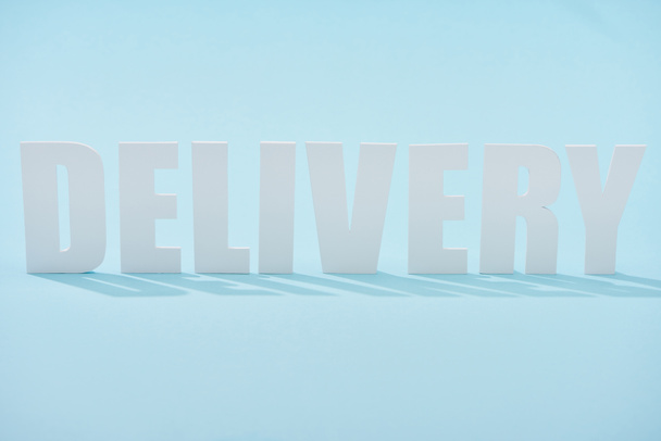 white delivery lettering with shadows on blue background - Foto, Imagem