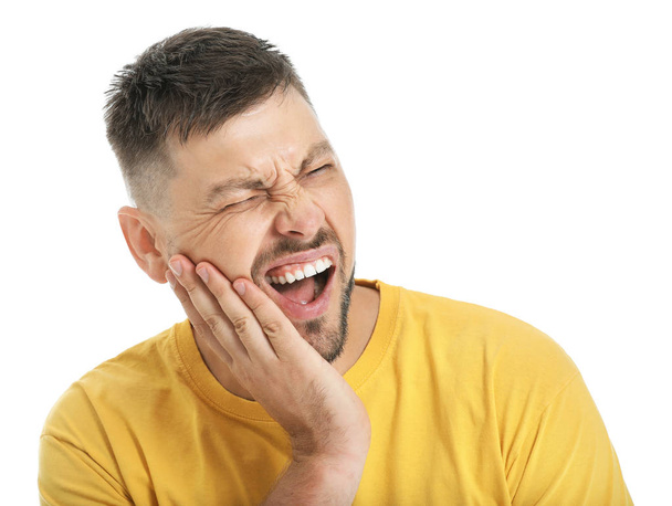 Mies kärsii hammassärystä valkoista taustaa vasten
 - Valokuva, kuva