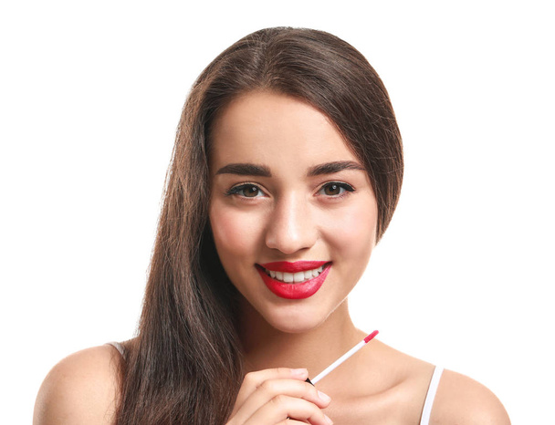 Beautiful young woman with lipstick on white background - 写真・画像
