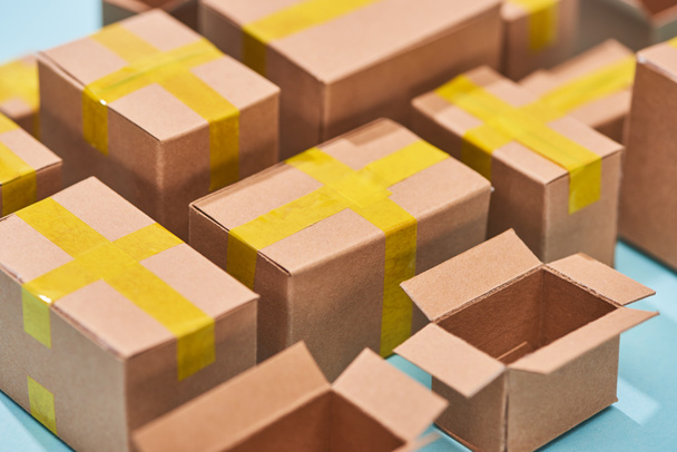 close up view of cardboard postal boxes on blue background - Foto, afbeelding