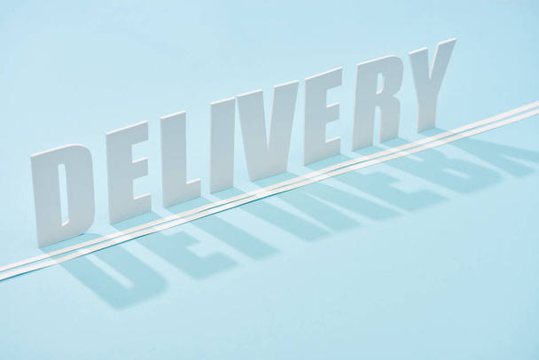 white delivery inscription with shadow and double line on blue background with copy space - Foto, Imagen
