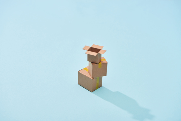 miniature carton boxes on blue background with copy space - Foto, Bild