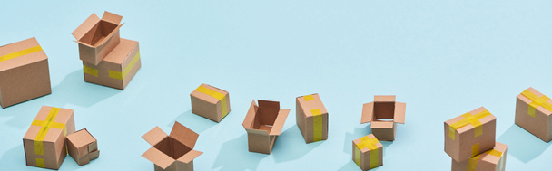 panoramic view of miniature postal boxes with yellow adhesive tape on blue background - Photo, Image