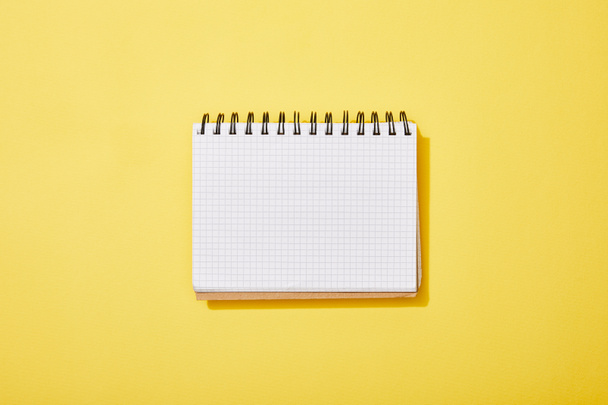 top view of blank white notebook on yellow background - Zdjęcie, obraz
