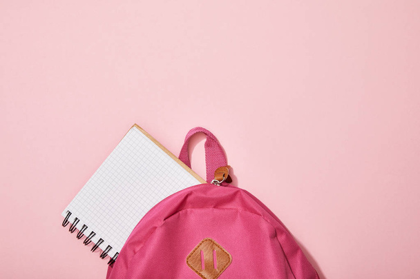 top view of blank notebook near backpack isolated on pink - Fotoğraf, Görsel