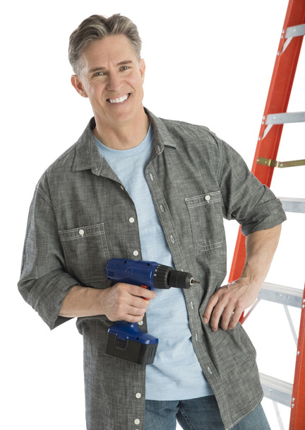 Porträt eines glücklichen Zimmermanns mit Bohrmaschine - Foto, Bild