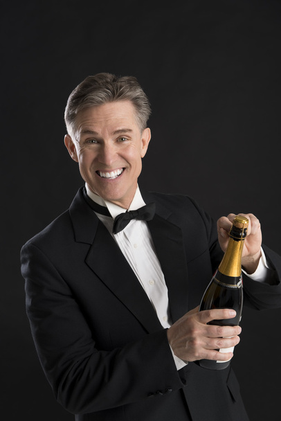 Portrait Of Cheerful Man In Tuxedo Opening Champagne Bottle - Photo, Image