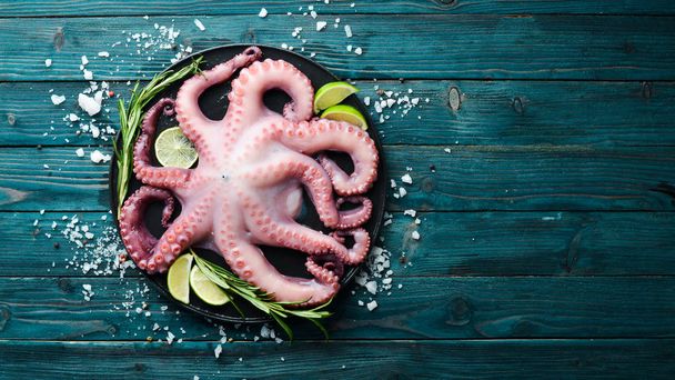 Raw octopus. On a blue wooden background. Top view. Free copy space. - Fotoğraf, Görsel