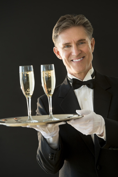 Щасливі офіціант тримає виступає лоток з шампанське флейти - Фото, зображення