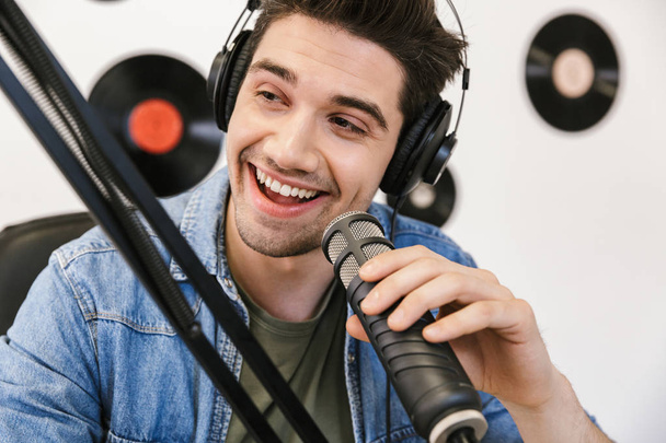 Cheerful young man radio host broadcasting - Foto, afbeelding