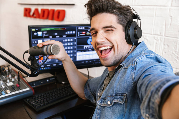 ハンサム幸せな若い男性ラジオホスト放送 - 写真・画像