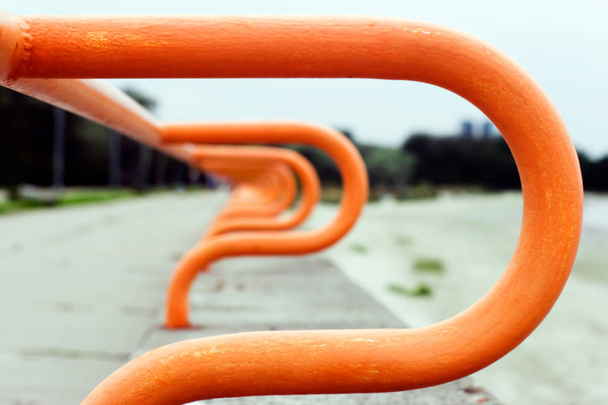 Abstract background. Blurred curved railing of the promenade going into the distance. The metal is painted orange. - Photo, Image