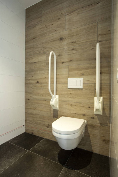Na casa de banho desactivada. vaso sanitário com barras de apoio para idosos ou deficientes, conceito incapacitante. design moderno
 - Foto, Imagem
