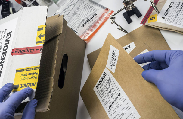 Experto en policía guardado en una caja de registros y pruebas de un caso de asesinato en el laboratorio científico
 - Foto, Imagen