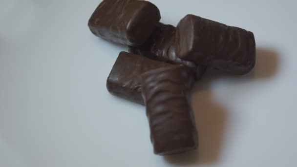 Cukierki czekoladowe obracają się na białym tle - Materiał filmowy, wideo