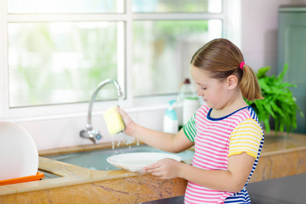 Child washing dishes.  - Foto, imagen