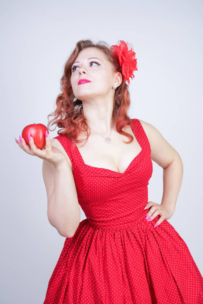 Sexy joven pin-up chica sosteniendo manzana roja en su mano
 - Foto, imagen