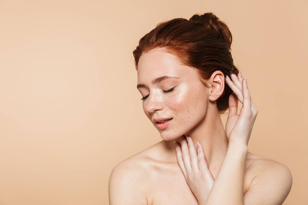Amazing young redhead woman posing isolated over beige wall background. - 写真・画像