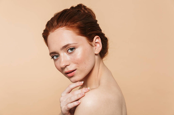Young redhead woman posing isolated over beige wall background. - Foto, Bild