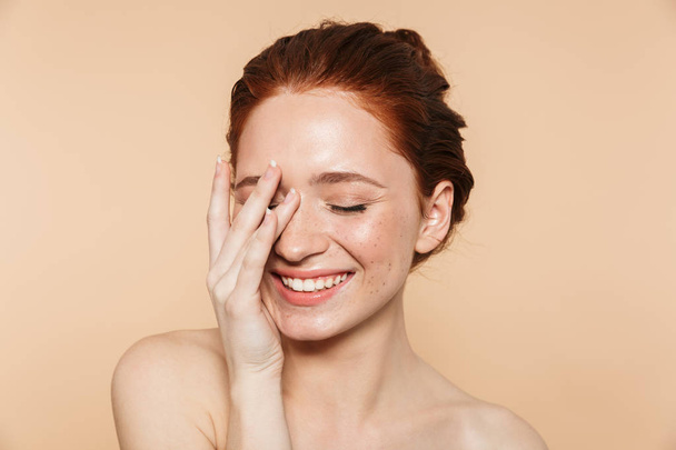 Amazing young redhead woman posing isolated over beige wall background. - 写真・画像
