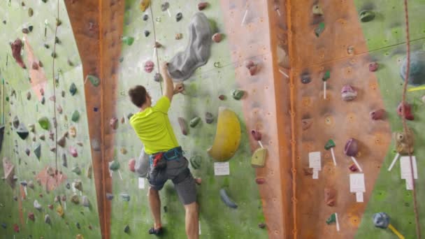 Kiipeily urheilu käsite: Mies kiipeilijä seinälle. Sisäuima kiipeily urheilu käsite: mies kiipeilijä keinotekoinen kiipeilyseinä
 - Materiaali, video