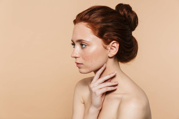Young redhead woman posing isolated over beige wall background. - Foto, Imagem
