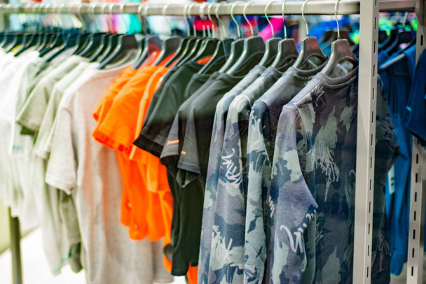 Modne i eleganckie ubrania wiszące na wieszaku w sklepie dla miłośników wyboru wysokiej jakości i pasji zakupy - Zdjęcie, obraz