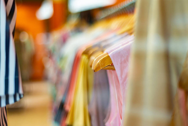 Divatos és elegáns ruhák lóg egy vállfa egy boltban szerelmeseinek a választás a magas színvonalú és szenvedélyes vásárlás - Fotó, kép
