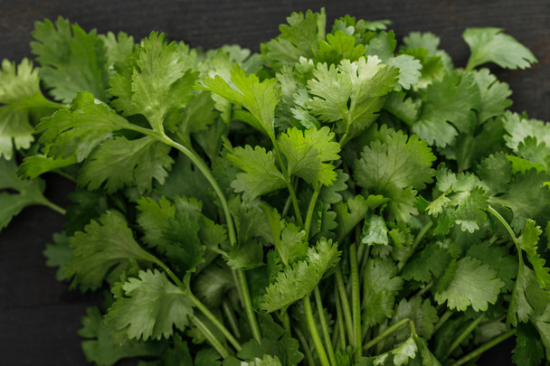 Close up view of fresh green parsley bundle on dark surface - Photo, Image