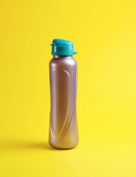 geschlossene Plastiksportflasche auf gelbem Hintergrund - Foto, Bild