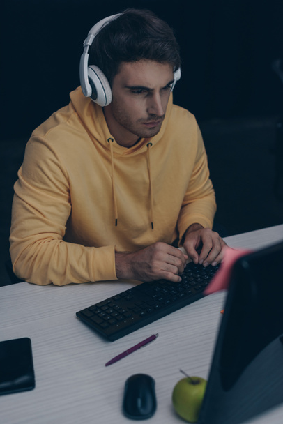 joven programador en auriculares trabajando de noche en la oficina
 - Foto, Imagen