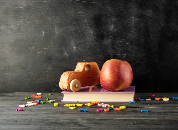 olgun kırmızı elma, eski oyuncak araba bir kitap standı - Fotoğraf, Görsel
