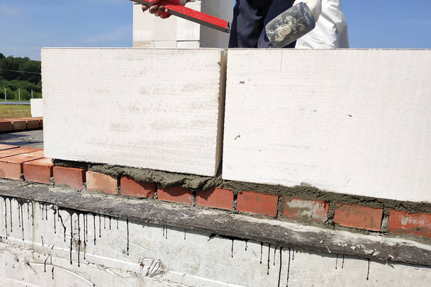 Pracovník měří pracovní zeď s úrovní. - Fotografie, Obrázek