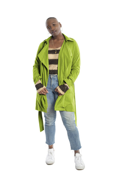 Black African American fashion model with bald hairstyle confidently posing with a vibrant lime green colored jacket for fall collection.  Depicts fashion design and clothing apparel - 写真・画像
