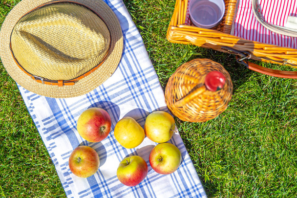 Concepto de picnic con cesta en césped verde soleado en el parque
 - Foto, Imagen