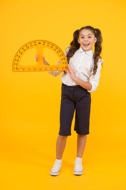 Schoolgirl holding protractor for lesson. Little child preparing for geometry. Adorable small girl using measuring instrument. Study geometry. Future architect. Engineering course. Geometry concept - Photo, image