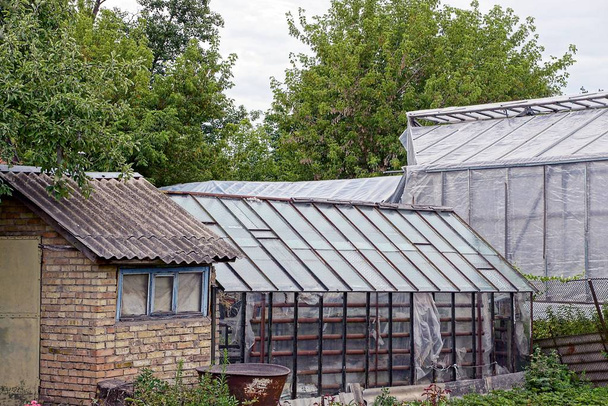 Brick barn and greenhouses in the yard on a plot in the garden - Photo, Image