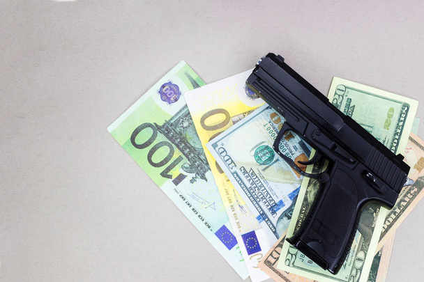 cocaïne, marihuana dollars en pistool in geval op houten tafel op grijze achtergrond - Foto, afbeelding