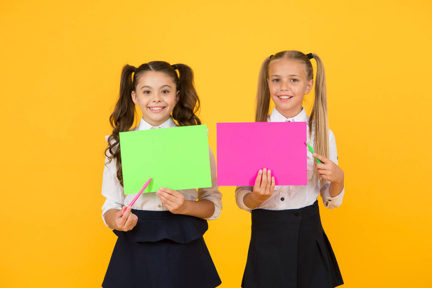 School girls show poster. Presentation poster copy space. Children presenting own projects. Explain main point. Girls school uniform hold poster. Visual communication concept. School friendship - Фото, изображение