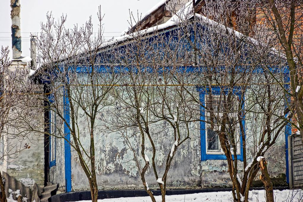 Ένα αρχαίο εξοχικό πίσω από μια χειμωνιάτικη αυλή - Φωτογραφία, εικόνα