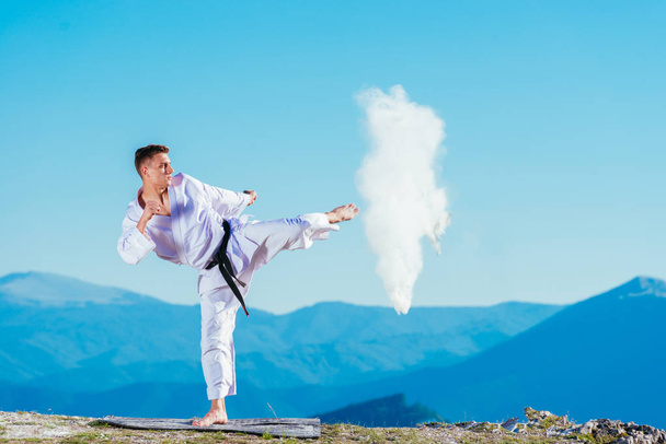 Fit karate atlet kopání pohár naplněný whit fluor způsobuje velký - Fotografie, Obrázek