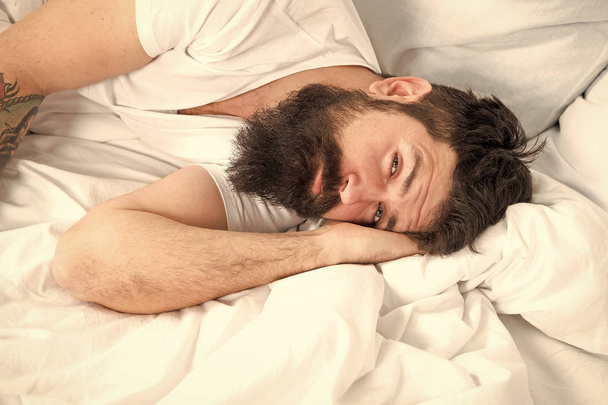 Sleep disorders concept. What a long night. Man bearded hipster having problem with sleep. Guy lying in bed try to relax and fall asleep. Relaxation techniques. Violations of sleep and wakefulness - Photo, image